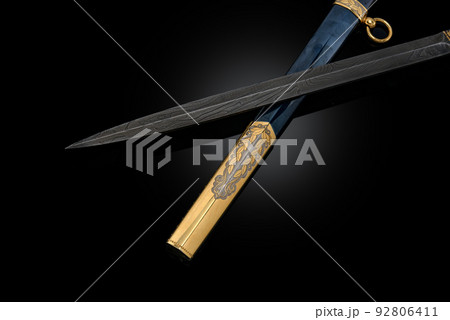 souvenir collectible silver gold dagger cutlass with scabbard, with metal engraving, on black background. Luxury weapons with traditional patterns in medieval vintage style. souvenir collectible silver gold dagger cutlass with scabbard, with metal engraving, on black background. Luxury weapons with traditional patterns in medieval vintage style. 92806411