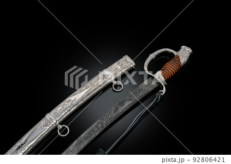 souvenir collectible silver gold dagger cutlass with scabbard, with metal engraving, on black background. Luxury weapons with traditional patterns in medieval vintage style. souvenir collectible silver gold dagger cutlass with scabbard, with metal engraving, on black background. Luxury weapons with traditional patterns in medieval vintage style. 92806421