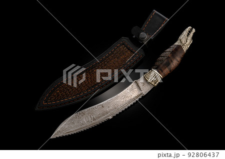 souvenir collectible silver gold dagger cutlass with scabbard, with metal engraving, on black background. Luxury weapons with traditional patterns in medieval vintage style. 92806437