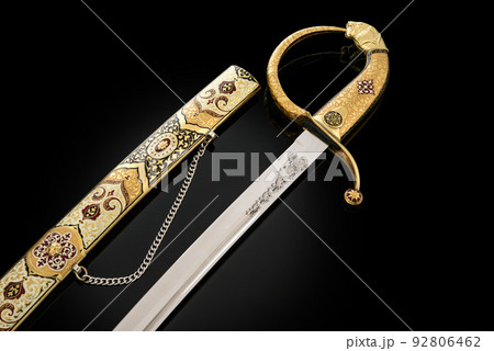 souvenir collectible silver gold dagger cutlass with scabbard, with metal engraving, on black background. Luxury weapons with traditional patterns in medieval vintage style. souvenir collectible silver gold dagger cutlass with scabbard, with metal engraving, on black background. Luxury weapons with traditional patterns in medieval vintage style. 92806462