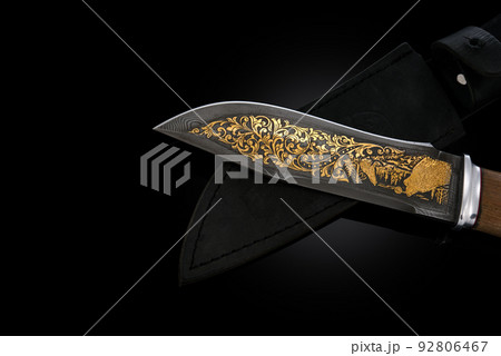 souvenir collectible silver gold dagger cutlass with scabbard, with metal engraving, on black background. Luxury weapons with traditional patterns in medieval vintage style. souvenir collectible silver gold dagger cutlass with scabbard, with metal engraving, on black background. Luxury weapons with traditional patterns in medieval vintage style. 92806467