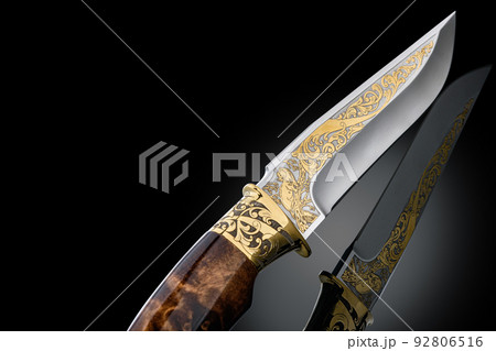 souvenir collectible silver gold dagger cutlass with scabbard, with metal engraving, on black background. Luxury weapons with traditional patterns in medieval vintage style. souvenir collectible silver gold dagger cutlass with scabbard, with metal engraving, on black background. Luxury weapons with traditional patterns in medieval vintage style. 92806516