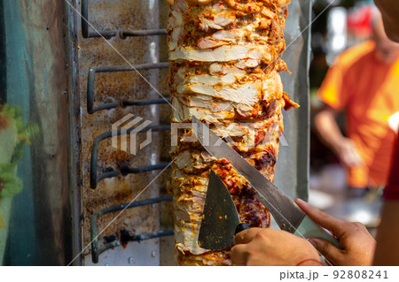 Chef cutting with doner knife Traditional Turkish Doner Kebab meat. 92808241