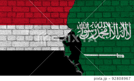 Saudi Arabia vs Yemen. Flags of countries on brick wall with the silhouettes of a military 92808967