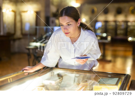Woman looking at the exposition of mediaeval boxes Woman looking at the exposition of mediaeval boxes 92809729