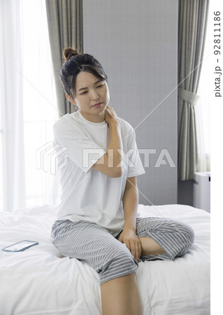 寝起きで肩が凝る若い女性 92811186