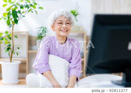 笑顔でテレビを見るシニア女性 92811377
