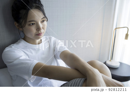 ベッドルームでボーっとする若い女性 92812211