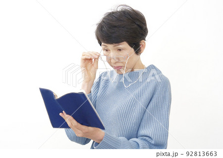 読書する老眼のシニア女性　白バック 92813663