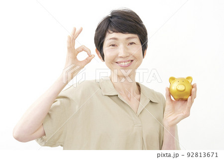 貯金箱を持ってOKジェスチャーするシニア女性 白バック 貯金箱を持ってOKジェスチャーするシニア女性 白バック 92813671