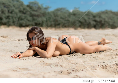 Topless woman lying on beach 92814568