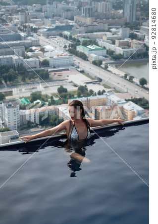 Woman in swimming pool on roof 92814680