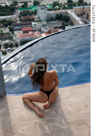 Anonymous seductive woman at poolside on roof Anonymous seductive woman at poolside on roof 92814741