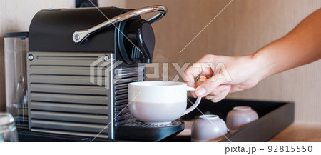 Hand making Espresso by Coffee Machine with capsules on wood table Hand making Espresso by Coffee Machine with capsules on wood table 92815550