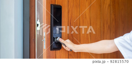 man holding handle of smart digital door lock while open or close the door. Technology, electrical and lifestyle concepts 92815570