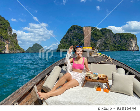 Woman tourist in private longtail boat trip to island with exotic food picnic, Krabi, Thailand. landmark, destination, Asia Travel, vacation, wanderlust and holiday concept 92816444