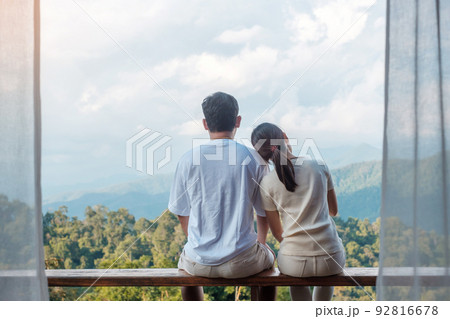 Couple tourist relaxing and looking mountain view at countryside home or homestay in the morning. Vacation, together travel, honeymoon, blogger, journey, trip and relaxing concept 92816678
