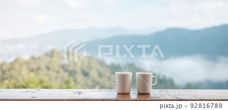 couple White mug of hot coffee or tea on wooden table in the morning with mountain and nature background couple White mug of hot coffee or tea on wooden table in the morning with mountain and nature background 92816789