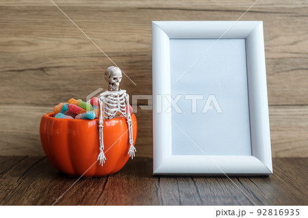 Orange pumpkin bowl and candies on table and frame with copy space for text. Happy Halloween day, Hello October, fall autumn season, Festive, party and holiday concept 92816935