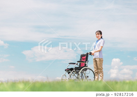 青空の中で車椅子を持つ介護士・作業療法士 92817216