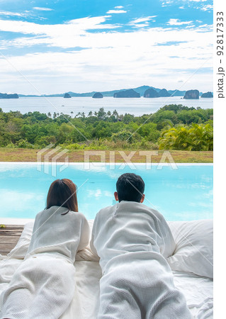 Happy Couple traveler enjoy Beautiful ocean view, Tourists relaxing in tropical luxury resort with swimming pool.Together, honeymoon, love, travel and summer vacation concept 92817333