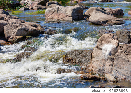 Stormy and swift water flow among huge stone boulders. Stormy and swift water flow among huge stone boulders. 92828898