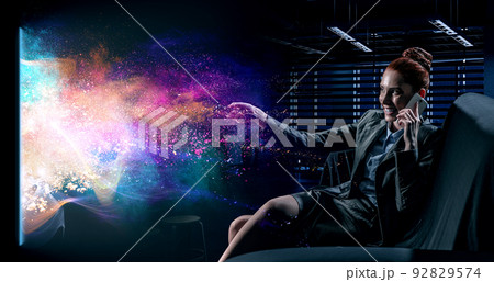 Young woman watching movie . Mixed media Young woman watching movie . Mixed media 92829574