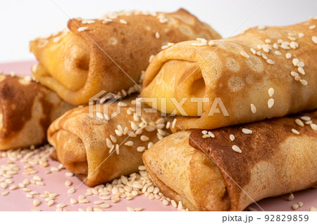 Pancakes homemade with sesame seeds on a pink plate. Delicious sweet breakfast with sugar. 92829859
