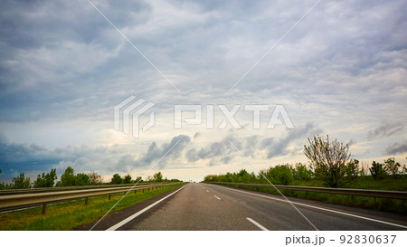The highway traffic in sunset before the thunderstorm The highway traffic in sunset before the thunderstorm 92830637