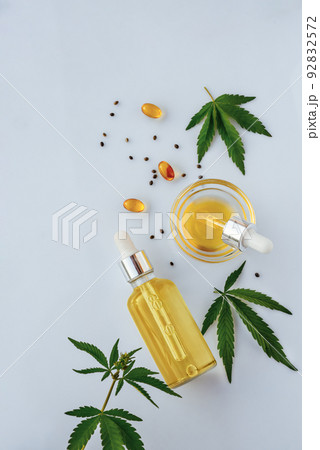 CBD oil in bottle with pipette, capsules, marijuana leaves on white background 92832572