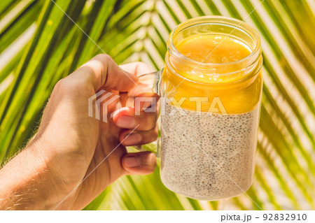 Chia seed pudding with almond milk and fresh mango topping in hand 92832910