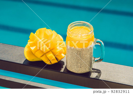 Chia seed pudding with almond milk and fresh mango topping on the background of the pool Chia seed pudding with almond milk and fresh mango topping on the background of the pool 92832911