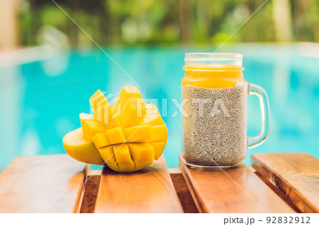 Chia seed pudding with almond milk and fresh mango topping on the background of the pool Chia seed pudding with almond milk and fresh mango topping on the background of the pool 92832912