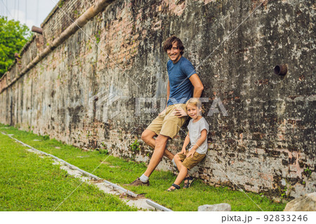 Dad and son on background of Fort Cornwallis in Georgetown, Penang, is a star fort built by the British East India Company in the late 18th century, it is the largest standing fort in Malaysia Dad and son on background of Fort Cornwallis in Georgetown, Penang, is a star fort built by the British East India Company in the late 18th century, it is the largest standing fort in Malaysia 92833246
