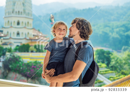 Father and son tourists in Buddhist temple Kek Lok Si in Penang, Malaysia, Georgetown. Traveling with children concept Father and son tourists in Buddhist temple Kek Lok Si in Penang, Malaysia, Georgetown. Traveling with children concept 92833339