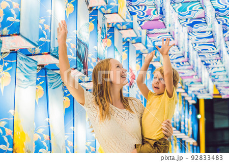 Mom and son on the background of Asian lanterns celebrate the Chinese New Year Mom and son on the background of Asian lanterns celebrate the Chinese New Year 92833483