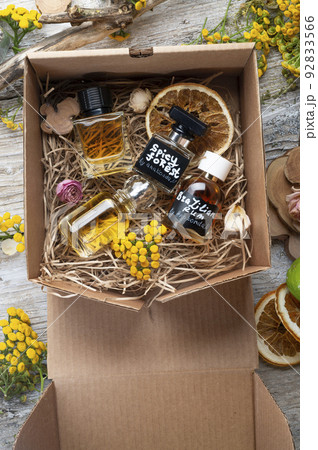 author collection of perfumes  around yellow flowers and ingridients  served in box .top view. perfumery  and  life style concept 92833566