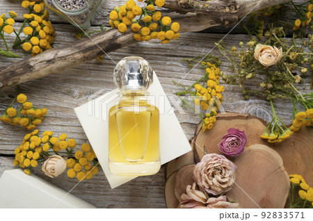 perfume bottles around yellow flowers and ingridients  at  wooden old style background . flat lay. perfumery concept 92833571