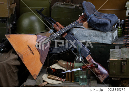 Russian army - kalashnikov AK 47 and balalaika with ammunition on army green crates. Russian army - kalashnikov AK 47 and balalaika with ammunition on army green crates. 92836375