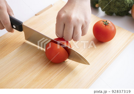 野菜を切る女性の手元 92837319