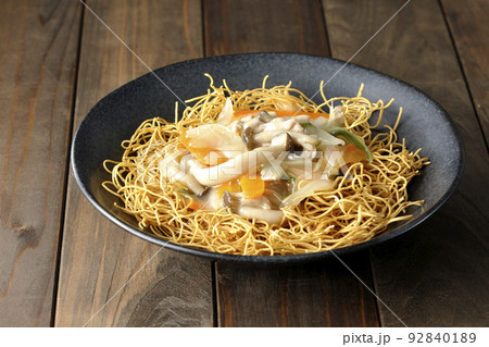 しめじや人参、玉葱などが入っている餡がかかった皿うどん しめじや人参、玉葱などが入っている餡がかかった皿うどん 92840189