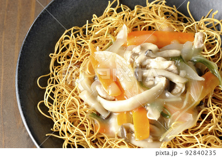 しめじや人参、玉葱などが入っている餡がかかった皿うどんを俯瞰で撮影 92840235