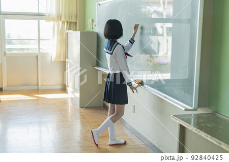 黒板に文字を書く女子高生 92840425