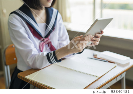 授業中にタブレット端末を使う女子高生 92840481
