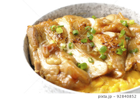 玉子焼に大きい鶏肉が乗っている照り焼きチキン丼を白背景で撮影 92840852