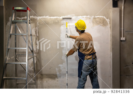 Prime oil based primer on old concrete wall before applying the main color.  renovation concept 92841336