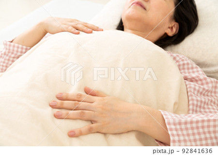 パジャマを着て寝室で眠るミドル女性 92841636