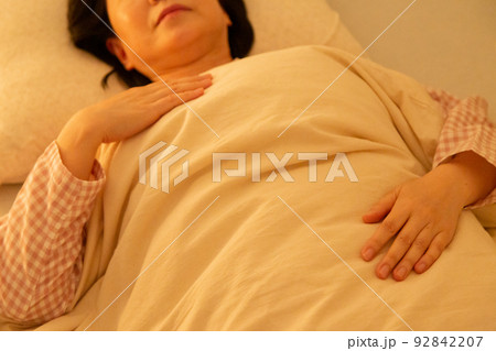 パジャマを着て寝室で眠るミドル女性 92842207