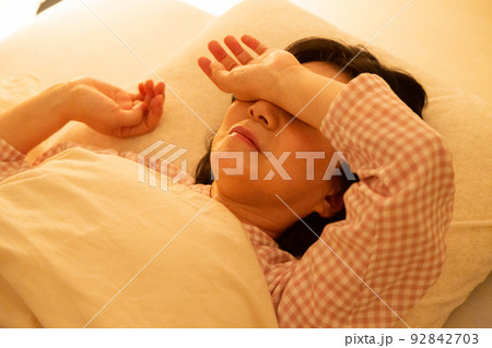 パジャマを着て寝室で眠るミドル女性 92842703