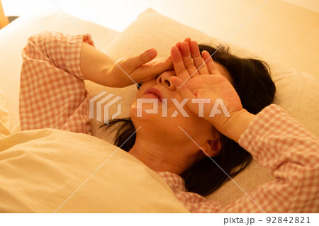 パジャマを着て寝室で眠れないミドル女性 92842821